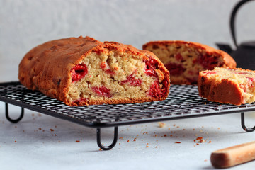 Fresh moist homemade delicious raspberry cake on black cooling rack