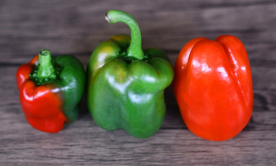 Red and green paprika on wood background.