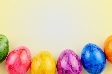 Colored Easter eggs on yellow background.