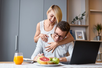 Cheerful woman hugging man making notes