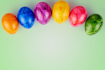 Colored Easter eggs on green background.