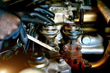 Plakat Auto mechanic Preparing For the work. Mechanic with Stainless Steel Wrench in Hand.Close up of hands mechanic doing car service and maintenance.Engine Maintenance concept