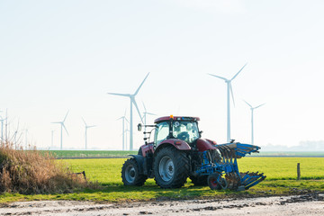 Bauer mit seinem Traktor in Dithmarschen Schleswig-Holstein mitten in einem riesigen Windpark © penofoto.de