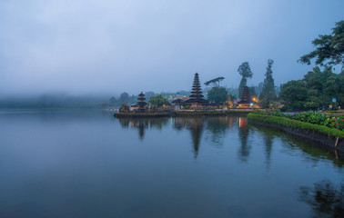 Fototapeta na wymiar Pura Ulan Danu Bratan a famous picturesque landmark and a significant temple on the shores of Lake Bratan in Bali, Indonesia. View with the fog in the morning. 