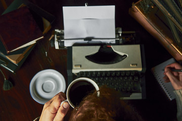 Young man writing on old typewriter.