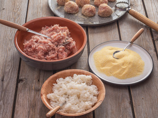 A set of products for making meatballs: minced turkey meat, boiled rice and corn grits.