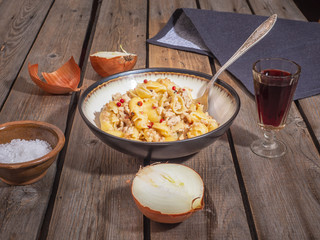 Pasta lunch with meat and a glass of red wine in a transparent cut glass