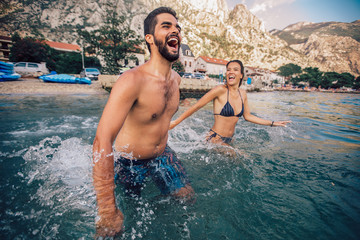 Sexy young loving couple on the beach having fun