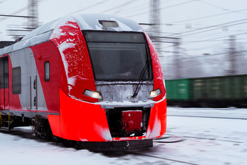 Fototapeta premium ice-covered multiple-unit train rides by rail in winter