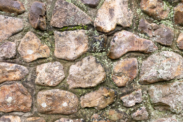 Close up of an old stone wall, with little bits of moss and weeds, perfect for backgrounds and abstracts