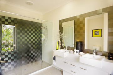 Fototapeta na wymiar stylish modern washroom with a glass shower and mirrors