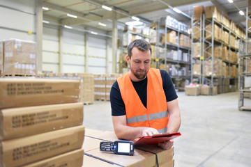 Warenbestandkontrolle durch Arbeiter im Lager - Gütertransport und Aufbwahrung im Handel //...