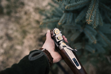 Man is charging his hunting guns. Male hunters is ready for hunting.  Detail on rifle and...
