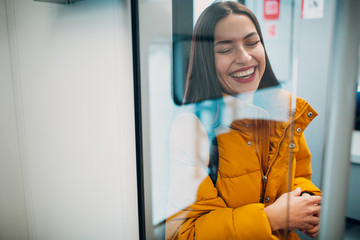 Positive young female in public transport, bus, tram, trolley bus.