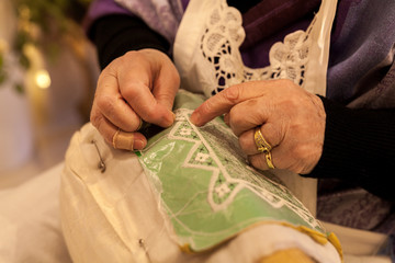elderly while embroidering a lace in burano island near venice in italy