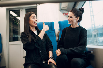 Two girlfriends having fun by railway train.  Women Friendship Concept.