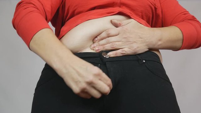 Fat lady makes an effort to fasten her pants, weight problems, diet