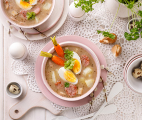 The sour soup (Żurek), polish Easter soup with the addition of sausage, hard boiled egg and vegetables in a ceramic bowl. Traditional Easter food in Poland