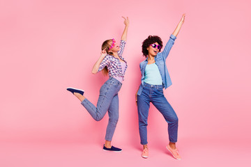 Full length body size portrait of two person nice cool crazy careless attractive charming cheerful cheery playful girls wearing casual checkered shirt having fun isolated over pink pastel background