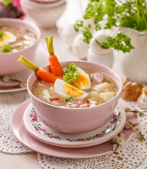 The sour soup (Żurek), polish Easter soup with the addition of sausage, hard boiled egg and vegetables in a ceramic bowl. Traditional Easter food in Poland