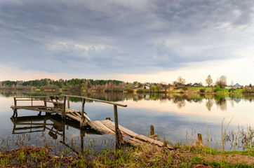 Autumn forest with golden foliage and blue lake. Sunny day and cloudy blue sky.