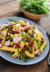 Penne pasta with tuna chunks, rucola and dry tomatoes