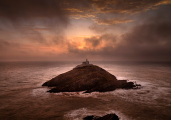 Glorious clouds at daybreak over Mumbles lighthouse in Swansea, South Wales, UK
