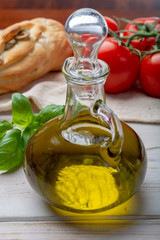 Virgin natural olive oil is glass bottle, served with traditional Mediterranean food