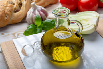 Virgin natural olive oil is glass bottle, served with traditional Mediterranean food