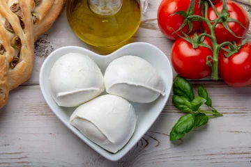 Foto auf Acrylglas Liebesmozzerella, Büffelmozzarellabällchen, weicher italienischer Käse aus der Milch italienischer mediterraner Büffel in herzförmiger Platte © barmalini