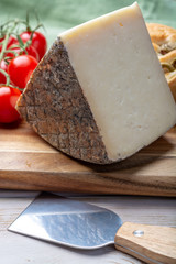 Italian cheese, piece of mature Tuscan Pecorino sheep cheese served with olive bread and tomatoes