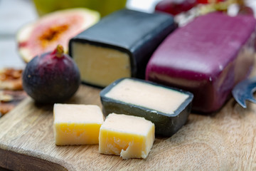 Mini black and dark red waxed cheddar cheeses made from West Country milk and and age-old methods in England