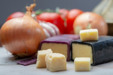 Mini black and dark red waxed cheddar cheeses with strong flavor made from West Country milk and and age-old methods with onion and garlic in England