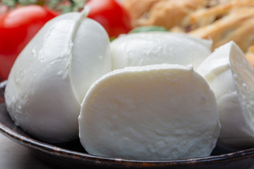Balls and pieces of buffalo mozzarella, soft Italian scheese made from the milk of Italian Mediterranean buffalo