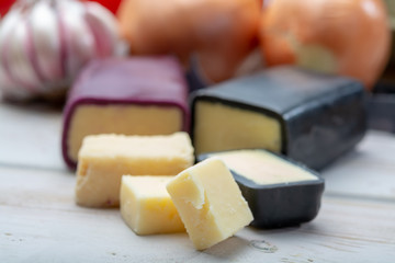 Mini black and dark red waxed cheddar cheeses with strong flavor made from West Country milk and and age-old methods with onion and garlic in England