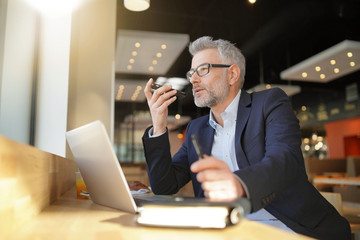 Businessman talking on cellphone during layover in airport