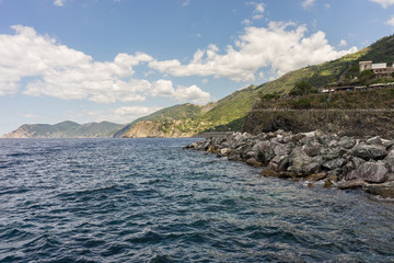 Italy, Cinque Terre, Monterosso, a large body of water with a mountain in the background
