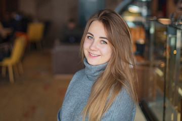 lifestyle, authentic, candid photo of face of a woman. a portrait of a beautiful woman with light hair, posing for a photo in the cafe interior