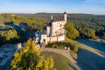 Fototapeta na wymiar Medieval Castle in Bobolice, Poland, built in 14th century, renovated in 20th century. One of strongholds called Eagles Nests in Polish Jurassic Highland in Silesia. Aerial view in sunrise light