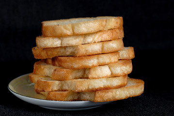 White toasted bread stacked in a pile on a plate. Shallow depth of field