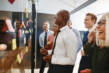 Laughing African businessman and his team brainstorming with sti