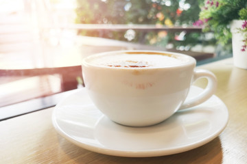 Orange peach color lipstick with white coffee cup rim on the wooden table Morning atmosphere by the balcony.