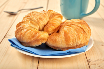 fresh baked croissants on wooden table