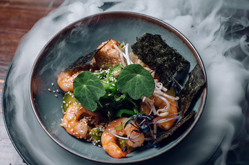 prawn salad with avocado, sea kale and sesame in ice vapor.