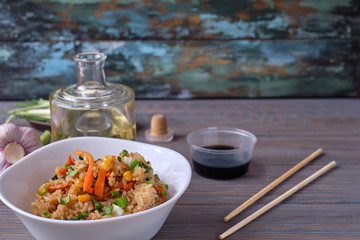 japanese food on a wooden table, fried rice with vegetables,  chopsticks. Asian/Japanese food.