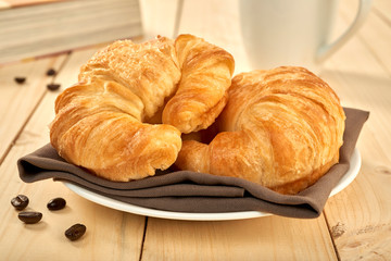 fresh baked croissants on wooden table