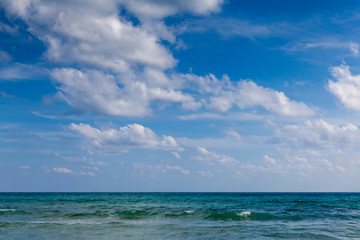 Seascape with clouds hanging over calm sea in calm weather. Tropical horizontal composition
