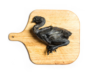 raw black chicken on wooden board