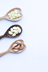 Garlic on wooden spoon on white