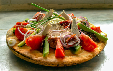 Balkan salad served on crispy bread.	 With cheese, flat sausage, tomatoes, cucumbers, pepper, hot pepper, mash, made of white cheese and yoghurt, appetizer with cheese and red pepper and red onion.
